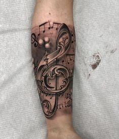 a man's arm with music notes on it and a treble in the shape of a letter