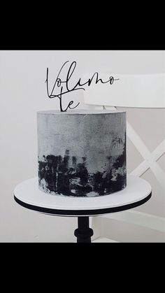 a black and white cake sitting on top of a table next to a sign that says dolano de