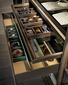 an open drawer in a kitchen with many different items inside and outside the drawers on each side