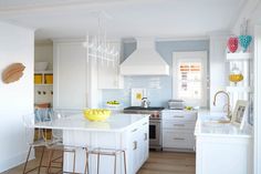 a kitchen with white cabinets and counter tops next to an island in the middle of the room