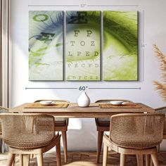 a dining room table with four chairs and an eye chart on the wall