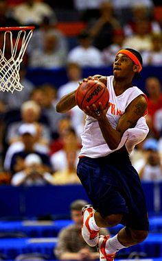 a man jumping up to dunk a basketball in front of an audience at a sporting event