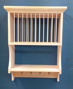 a wooden shelf with bars on it against a blue wall