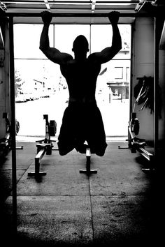 a man is hanging upside down in the gym