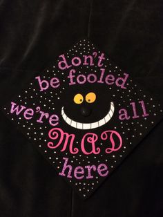 a graduation cap with the words don't be fooled, we're all mad here