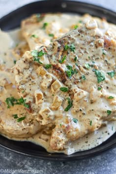 chicken with gravy in a skillet ready to be eaten and served on a plate