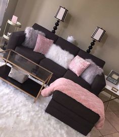 a living room filled with furniture on top of a white fluffy rug and two end tables