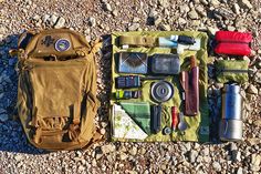 an assortment of items laid out on the ground next to a backpack and water bottle