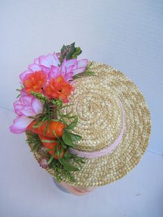 "* A cute mini boater hat has been trimmed out with Easter in mind. Hot pink and vibrant orange flowers complement the carrots off to the side making it a fun and festive hat to wear to any Easter event. * Designed on a 8.0\" diameter round straw hat with an elastic band on the inside. * Designed to look airy and light it would be perfect for a ladies luncheon, charity event or fashion show. * Fun to wear to any Easter Festival or Parade, Egg Hunt, Easter Dinner, Tea or Garden Party, Derby Event Whimsical Flower-shaped Mini Hats For Garden Party, Fun Orange Hats For Spring, Whimsical Flower Mini Hat For Garden Party, Adjustable Fun Mini Hats For Spring, Playful Pink Mini Hat For Summer, Flower-shaped Mini Hats For Spring Garden Party, Whimsical Mini Hats With Handmade Flowers For Summer, Whimsical Mini Hats With Handmade Flowers For Spring, Spring Mini Brimmed Hat With Handmade Flowers