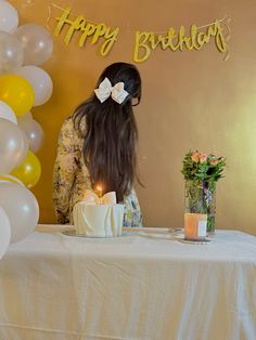 a woman sitting at a table in front of a birthday cake with candles on it