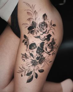 a woman's thigh with flowers and skulls on it