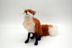 a stuffed fox sitting on top of a white floor