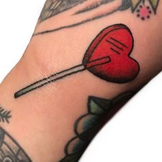 a red heart with an arrow sticking out of it's center on the arm