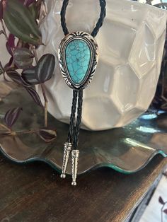 This awesome bolo tie has a southwestern design and agate centerpiece. The cord is genuine leather. Our bolos pair nicely with many of our belt buckles! They make wonderful gifts. The western bolo tie rope length is 39'' ; charm agate stone pendant size is 2'' x 1 1 /2'' Western Lariat Jewelry For Festival, Rustic Concho Jewelry For Rodeo, Rustic Concho Jewelry For Western-themed Events, Adjustable Turquoise Necklace For Western-themed Events, Bohemian Lariat Jewelry For Western-themed Events, Vintage Bolo Ties With Adjustable Length For Rodeo, Western Bolo Ties With Adjustable Length, Bohemian Hand Tooled Jewelry For Rodeo, Adjustable Vintage Bolo Ties For Ranch