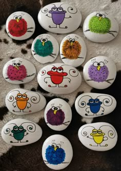 some very cute rocks painted with different colors and designs on them, sitting on a carpet