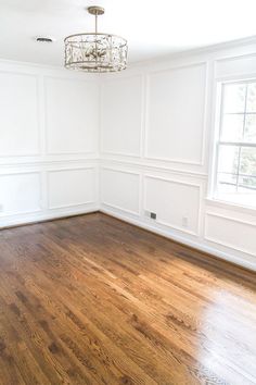 an empty room with hard wood floors and white walls