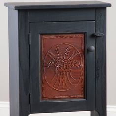 a small wooden cabinet with an intricate design on the front and side panel, in dark wood