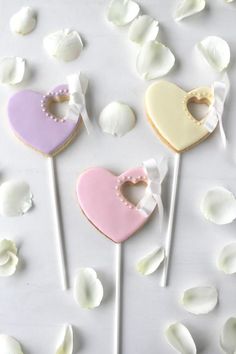 three heart shaped cookies sitting on top of marshmallows