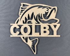 a wooden sign that says coby with a fish on it