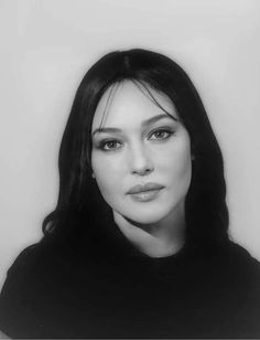 a black and white photo of a woman with long hair wearing a turtle neck sweater