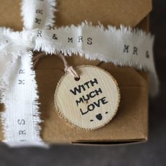 a wooden ornament that says with much love on it next to some tape