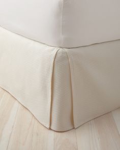 an unmade bed with white sheets and pillows