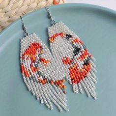 two birds made out of beads sitting on top of a plate