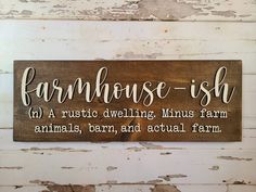 a wooden sign that says farmhouse ish on the side of a white painted wall