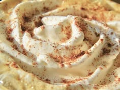 a close up view of some food in a bowl with whipped cream on top and cinnamon sprinkles