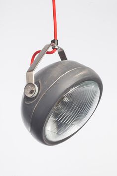 an industrial style light hanging from a red cord on a white background with clippings