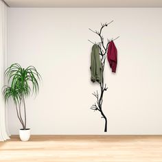 there is a coat rack on the wall next to a potted plant