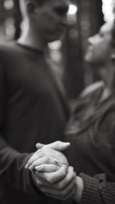 a man and woman holding hands while standing in front of each other with their eyes closed