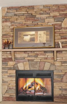 a fire place with a painting on the wall above it and a fireplace in front of it