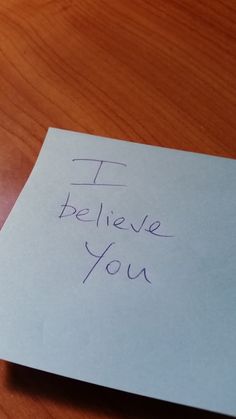 a piece of paper with writing on it that says i believe you next to a cell phone