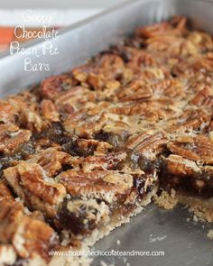 chocolate pecan pie bars in a pan with one slice cut out and ready to be eaten