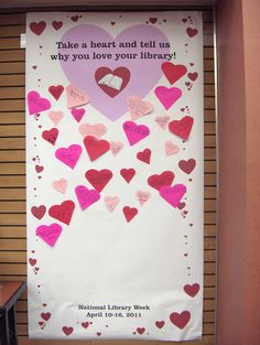 a valentine's day bulletin board with hearts on it and the words take a heart and tell us why you love your library