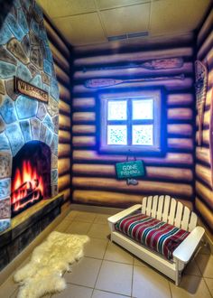 the interior of a log cabin with a chair and fire place in front of it