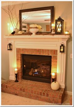 a fire place with candles on it and a mirror above the fireplace that says halloween mantel