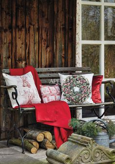 a wooden bench sitting next to a window filled with lots of pillows and other items