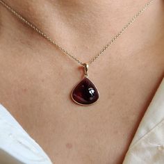 ITEM DESCRIPTION: >> The Pendant is made from Solid 14K Yellow Gold. Gemstone used is absolutely natural and ethically sourced. >> Natural Garnet in cabochon cut and pear shape with bezel setting is studded on it with utmost precision. >> This is a minimalist design and is absolutely hassle-free and everyday jewelry. Gem: Garnet Gem size: 14x14 mm pear Gem weight: 5.78 carats Gold purity: 14K (58.33% approx.) Gold weight: 0.49 grams Gross weight: 1.65 grams The Gold purity is guaranteed and it c Teardrop Cabochon Necklace For Anniversary, Anniversary Teardrop Cabochon Necklace, Anniversary Cabochon Teardrop Necklace, Elegant Gold Garnet Cabochon Jewelry, Pear-shaped Ruby Jewelry Gift, Elegant Amber Teardrop Pendant Jewelry, Formal Jewelry With Cabochon Teardrop Pendant, Elegant Garnet Teardrop Pendant Jewelry, Pear-shaped Gemstones For Gifts In Fine Jewelry Style