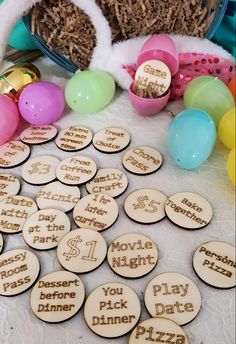 wooden badges with words on them sitting next to some balloons and other items in a basket