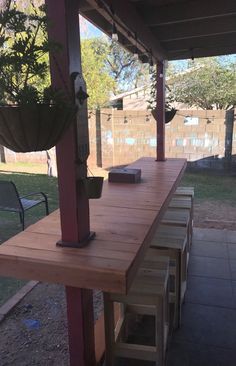 a wooden table sitting on top of a patio next to a potted planter