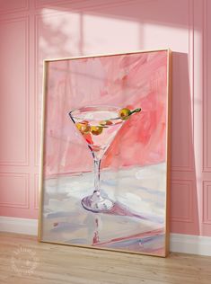 a painting of a martini glass with olives on the rim in front of a pink wall