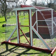 a red chicken coop sitting on top of a green field