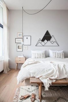 a bed with white sheets and pillows on top of it in a bedroom next to a window