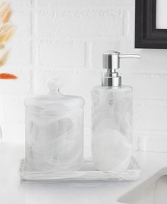 a white bathroom sink with soap dispenser and toothbrush holder