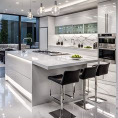 a modern kitchen with white cabinets and marble counter tops, black chairs and an island in the middle