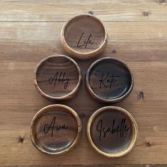 four wooden bowls with names on them sitting on a table