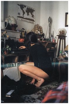 a woman sitting on the floor in front of a table