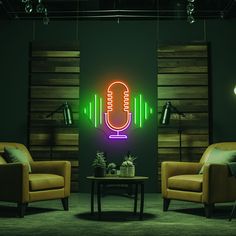 a room with two chairs and a table in front of a neon microphone on the wall